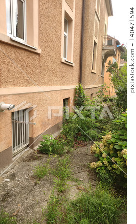 Unkempt garden growing wildly against building in croatia Unkempt garden growing wildly against building in croatia 140471594