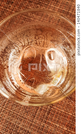 Refreshing glass of water with ice cubes on a wicker placemat 140471840
