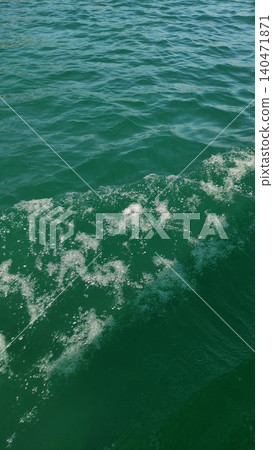 Motorboat creating a diagonal wake across emerald green water Motorboat creating a diagonal wake across emerald green water 140471871