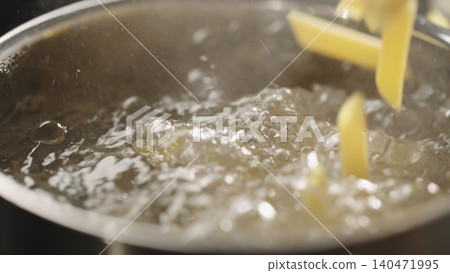 penne pasta falls in saucepan with boiling water penne pasta falls in saucepan with boiling water 140471995