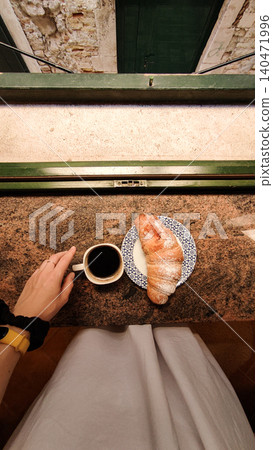 Woman enjoying breakfast with coffee and croissant in croatia Woman enjoying breakfast with coffee and croissant in croatia 140471996