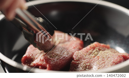 Close-up of raw steak fillet in black frying pan under soft directional light 140472002