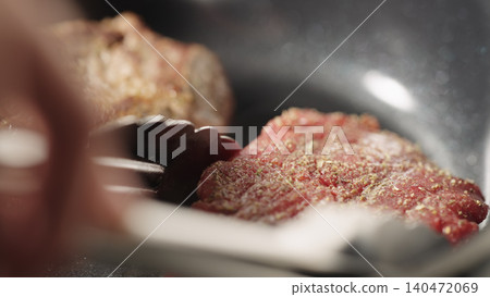Close-up of two beef fillet steaks searing in a hot skillet Close-up of two beef fillet steaks searing in a hot skillet 140472069