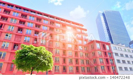 View of an modern apartment building standing next to a new modern office building with a glass facade. View of an modern apartment building standing next to a new modern office building with a glass facade. 140472248