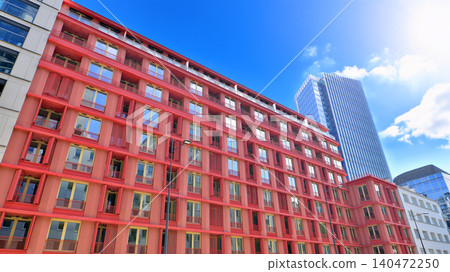 View of an modern apartment building standing next to a new modern office building with a glass facade. View of an modern apartment building standing next to a new modern office building with a glass facade. 140472250