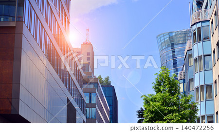 View of an modern apartment building standing next to a new modern office building with a glass facade. View of an modern apartment building standing next to a new modern office building with a glass facade. 140472256