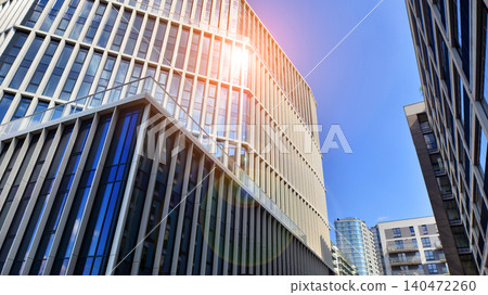 View of an modern apartment building standing next to a new modern office building with a glass facade. View of an modern apartment building standing next to a new modern office building with a glass facade. 140472260
