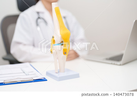 Doctor with Human Knee joint anatomy model. Osteoarthritis, Patellofemoral Pain Syndrome, Patellar Tendinitis, ACL, Anterior Cruciate Ligament, PCL, Posterior, MCL, Medial Collateral, LCL and Lateral 140473078