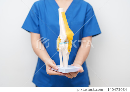 Doctor with Human Knee joint anatomy model. Osteoarthritis, Patellofemoral Pain Syndrome, Patellar Tendinitis, ACL, Anterior Cruciate Ligament, PCL, Posterior, MCL, Medial Collateral, LCL and Lateral 140473084