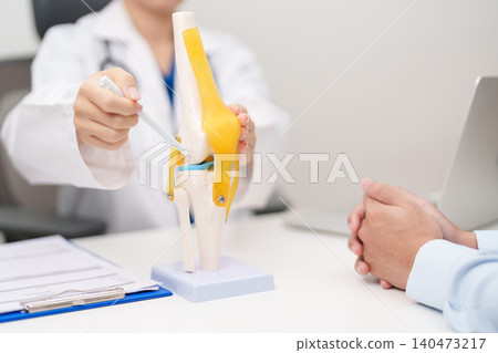 Doctor with Human Knee joint anatomy model. Osteoarthritis, Patellofemoral Pain Syndrome, Patellar Tendinitis, ACL, Anterior Cruciate Ligament, PCL, Posterior, MCL, Medial Collateral, LCL and Lateral 140473217