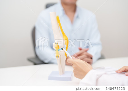 Doctor with Human Knee joint anatomy model. Osteoarthritis, Patellofemoral Pain Syndrome, Patellar Tendinitis, ACL, Anterior Cruciate Ligament, PCL, Posterior, MCL, Medial Collateral, LCL and Lateral 140473223