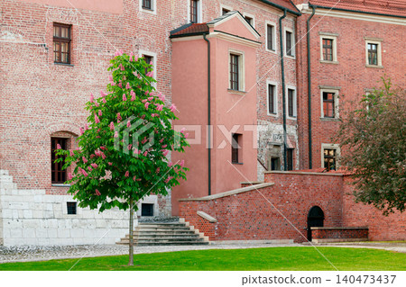 picturesque scene featuring ancient brick castle walls vibrant flowering tree and a well-maintained lawn, evoking a sense of timeless beauty and tranquility picturesque scene featuring ancient brick castle walls vibrant flowering tree and a well-maintained lawn, evoking a sense of timeless beauty and tranquility 140473437