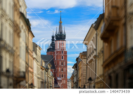 A view down a narrow street in Krakow, Poland, with colorful buildings flanking the path leading to the iconic Town Hall Tower A view down a narrow street in Krakow, Poland, with colorful buildings flanking the path leading to the iconic Town Hall Tower 140473439