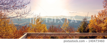 Autumn in the mountains. Panoramic view of the mountains and the valley in autumn from the wooden balcony. Carpathian Mountains. Bukovel, Ukraine. Real photo. Not AI Autumn in the mountains. Panoramic view of the mountains and the valley in autumn from the wooden balcony. Carpathian Mountains. Bukovel, Ukraine. Real photo. Not AI 140473460