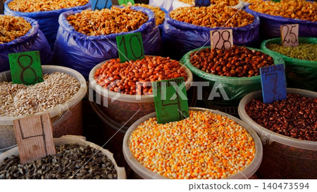 Colorful legumes, grains, spices displayed at outdoor market stall 140473594