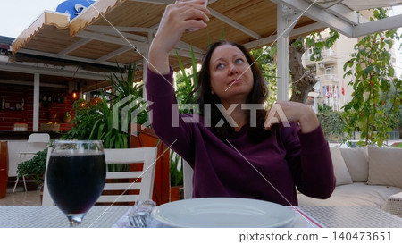 Woman taking selfie at outdoor restaurant patio dining Woman taking selfie at outdoor restaurant patio dining 140473651
