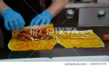 Chef preparing crepes with meat filling, professional kitchen Chef preparing crepes with meat filling, professional kitchen 140473774