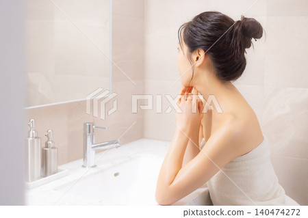 A woman doing body care in the bathroom. A woman doing body care in the bathroom. 140474272