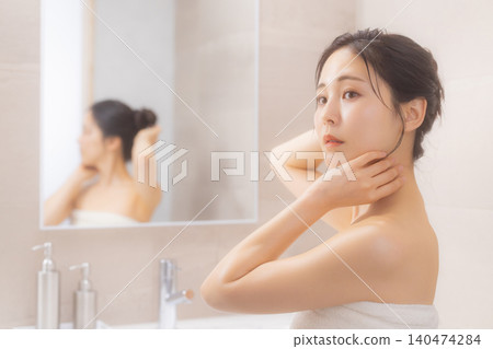 一位女士在浴室進行身體護理。 一位女士在浴室進行身體護理。 140474284