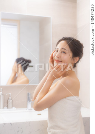 一位女士在浴室進行身體護理。 一位女士在浴室進行身體護理。 140474289