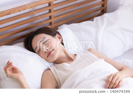 Woman sleeping soundly in bed Woman sleeping soundly in bed 140474399