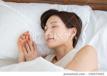 女人在床上睡得很香。 女人在床上睡得很香。 140474401