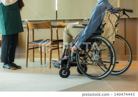 A man in a wheelchair and a female employee at a restaurant. A man in a wheelchair and a female employee at a restaurant. 140474443