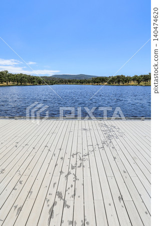 View from jetty looking across Dumaresq Dam in Armidale, New South Wales, Australia on a sunny day showing calm water and natural landscape environment in regional New England area. View from jetty looking across Dumaresq Dam in Armidale, New South Wales, Australia on a sunny day showing calm water and natural landscape environment in regional New England area. 140474620
