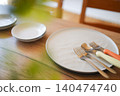 Tableware arranged on a wooden table, and cutlery for parent and child. 140474740