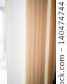 Soft light enters through the vertical blinds and window area. 140474744
