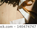 White and gold ribbons placed on a wooden table 140474747