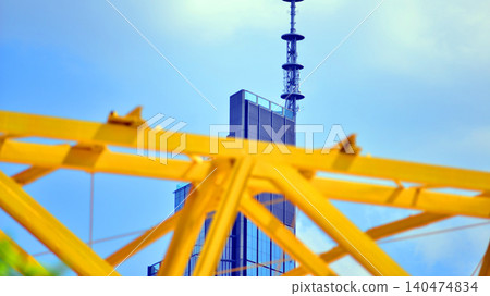 Yellow metal structure against the background of a skyscraper. Modern office building made of steel and glass Yellow metal structure against the background of a skyscraper. Modern office building made of steel and glass 140474834