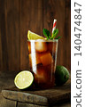 Refreshing cuba libre cocktail with cola, rum, lime, and mint, cold drink featuring ice cubes on rustic wooden table 140474847