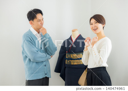 A woman struggling to decide which kimono to buy A woman struggling to decide which kimono to buy 140474961