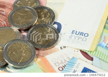 Close up of Euro coins on top of banknotes background. Close up of Euro coins on top of banknotes background. 140475012