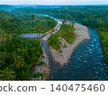 Terraced Rice Fields at Sunrise in Indonesia. Beautiful panoramic view of terraced rice fields surrounded by lush tropical greenery and palm trees 140475460