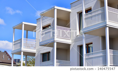 Modern residential structure showcasing a contemporary design with sloped roof, big windows and balconies. Modern residential structure showcasing a contemporary design with sloped roof, big windows and balconies. 140475547