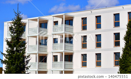 Modern residential structure showcasing a contemporary design with sloped roof, big windows and balconies. Modern residential structure showcasing a contemporary design with sloped roof, big windows and balconies. 140475551
