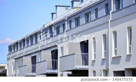 Modern residential structure showcasing a contemporary design with sloped roof, big windows and balconies. Modern residential structure showcasing a contemporary design with sloped roof, big windows and balconies. 140475555