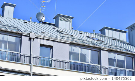 Modern residential structure showcasing a contemporary design with sloped roof, big windows and balconies. Modern residential structure showcasing a contemporary design with sloped roof, big windows and balconies. 140475562