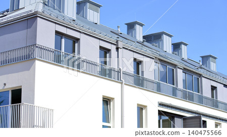 Modern residential structure showcasing a contemporary design with sloped roof, big windows and balconies. Modern residential structure showcasing a contemporary design with sloped roof, big windows and balconies. 140475566