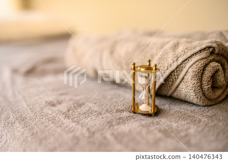 The passage of time and relaxation, hourglass and towel The passage of time and relaxation, hourglass and towel 140476343