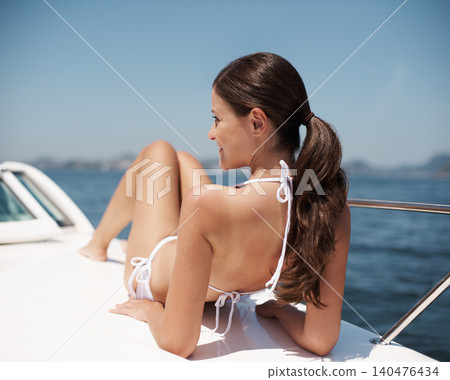 Travel, holiday and woman on boat in ocean for cruise, luxury sailing and transport for adventure. Bikini, summer fashion and person relax on yacht for tropical journey, vacation and tourism at sea 140476434