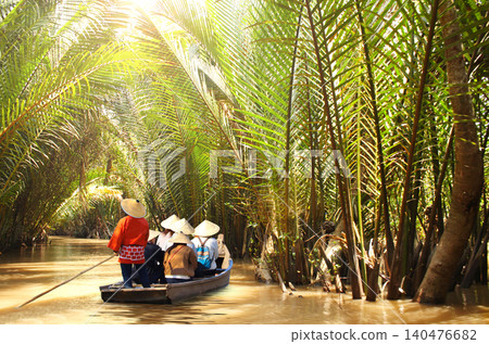 People boating in the delta of Mekong river, Vietnam, Asia. Famous tourist attraction boat ride on Mekong river. Summer vacation, relaxing, topic of travel, trip, cruises, tour People boating in the delta of Mekong river, Vietnam, Asia. Famous tourist attraction boat ride on Mekong river. Summer vacation, relaxing, topic of travel, trip, cruises, tour 140476682