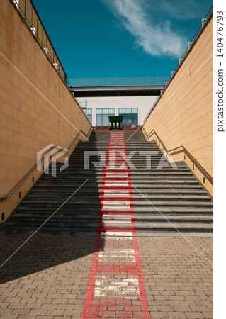 Perspective shot looking up a wide stone staircase with a painted center trail under sky Perspective shot looking up a wide stone staircase with a painted center trail under sky 140476793