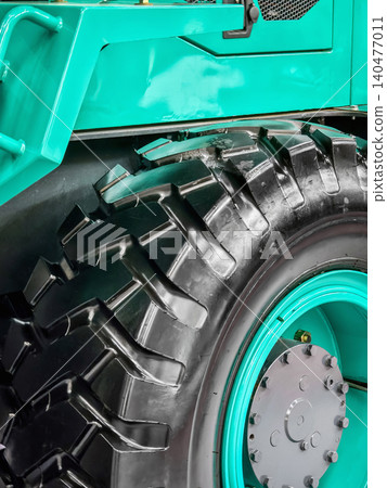 Heavy machinery tire close up shows deep treads and rugged surface at a construction site during daylight hours Heavy machinery tire close up shows deep treads and rugged surface at a construction site during daylight hours 140477011