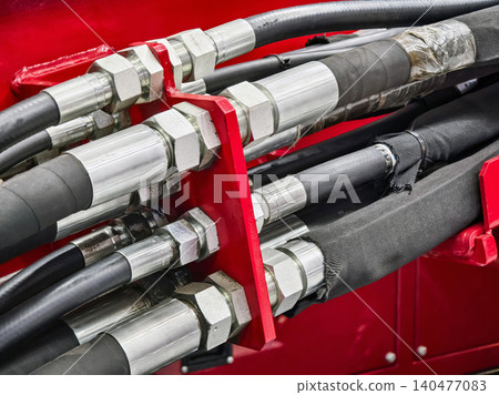 Close up of hydraulic hose and fitting assembly on construction equipment in industrial setting Close up of hydraulic hose and fitting assembly on construction equipment in industrial setting 140477083