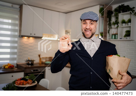 Man holding grocery bag showing ok sign in kitchen 140477473