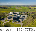 High-angle aerial view of a biogas plant with large dome tanks facing blooming yellow fields near Hammel, Denmark 140477501