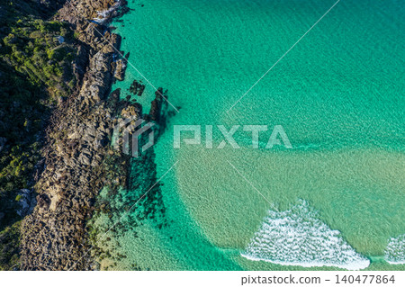 Aerial scene capturing the rocky shoreline of Charlotte Head meeting the sandy shore of Boomerang Beach near Pacific Palms, NSW, Australia.  140477864